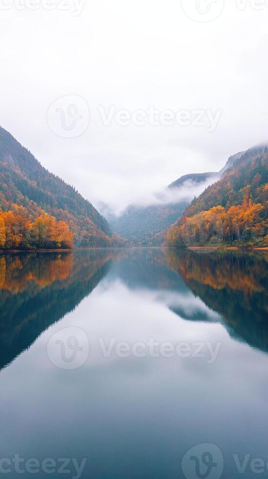 Misty Morning Lake with Autumn Forest Reflections and Mountain View Capturing Tranquil Beauty in Nature Landscape photo