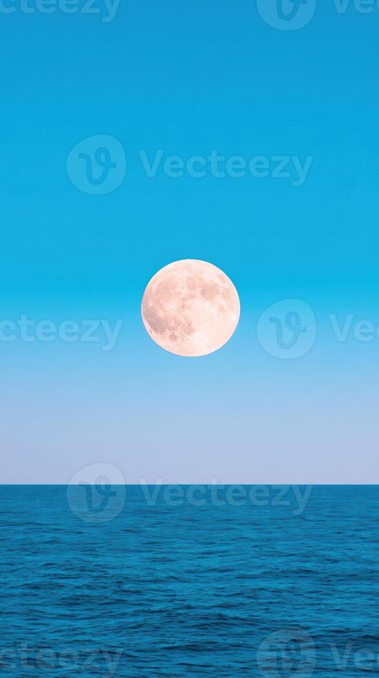 Moon Over Tranquil Sea with Blue Skies in Vertical Format, 916 Aspect Ratio, Ideal for Serene Nature Backgrounds and Celestial Themes. photo