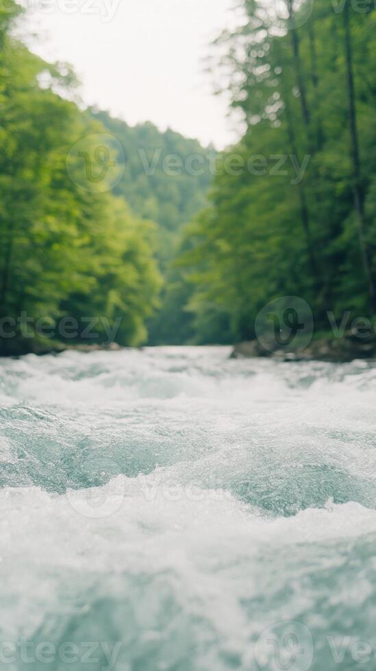 Serene River Flowing Through Lush Forest with Sunlight Streaming Through Trees in Vertical Shot for Nature Inspiration and Relaxation photo