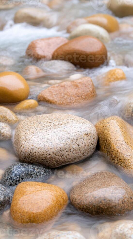 Vertical View of a Serene Stream Flowing Over Smooth Stones Capturing Natural Beauty and Peaceful Tranquility in Crisp Detail Presenting a Harmonious Blend of Earthy Tones and Flowing Water Motion photo