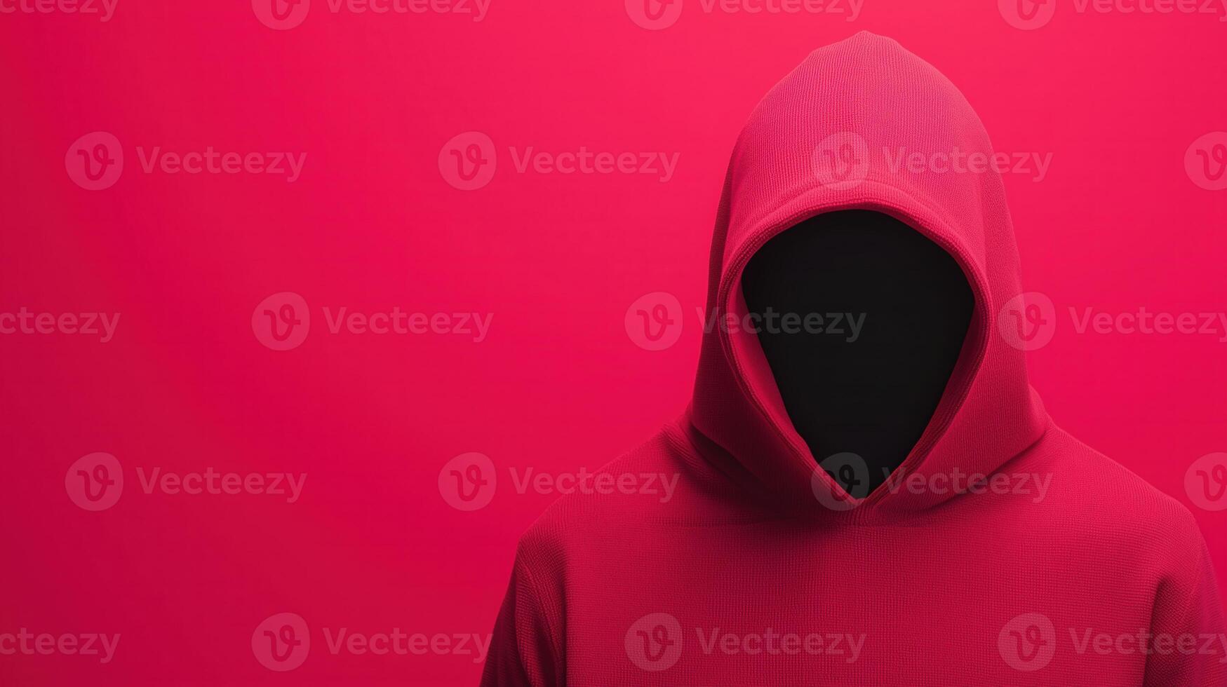 Anonymous Figure in Red Hoodie Representing Cybersecurity and Cybercrime Concepts, Against a Vivid Red Background photo