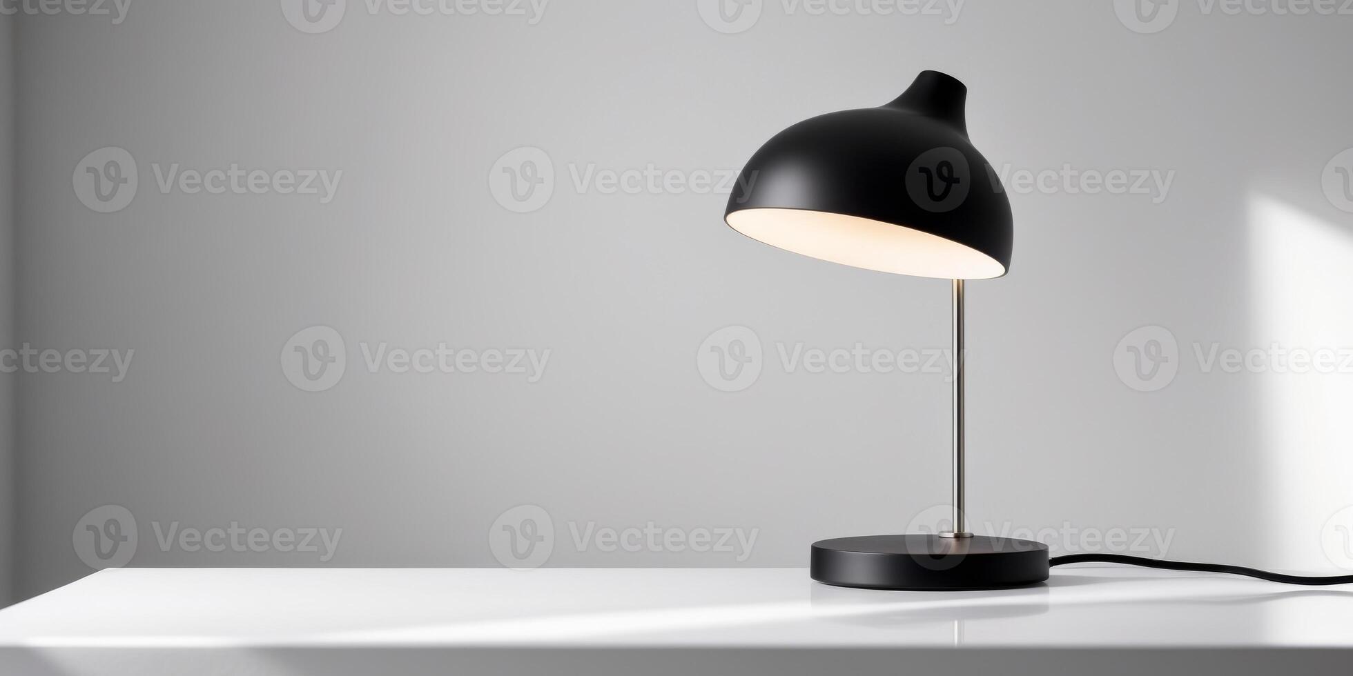 A black desk lamp is sitting on a white table photo