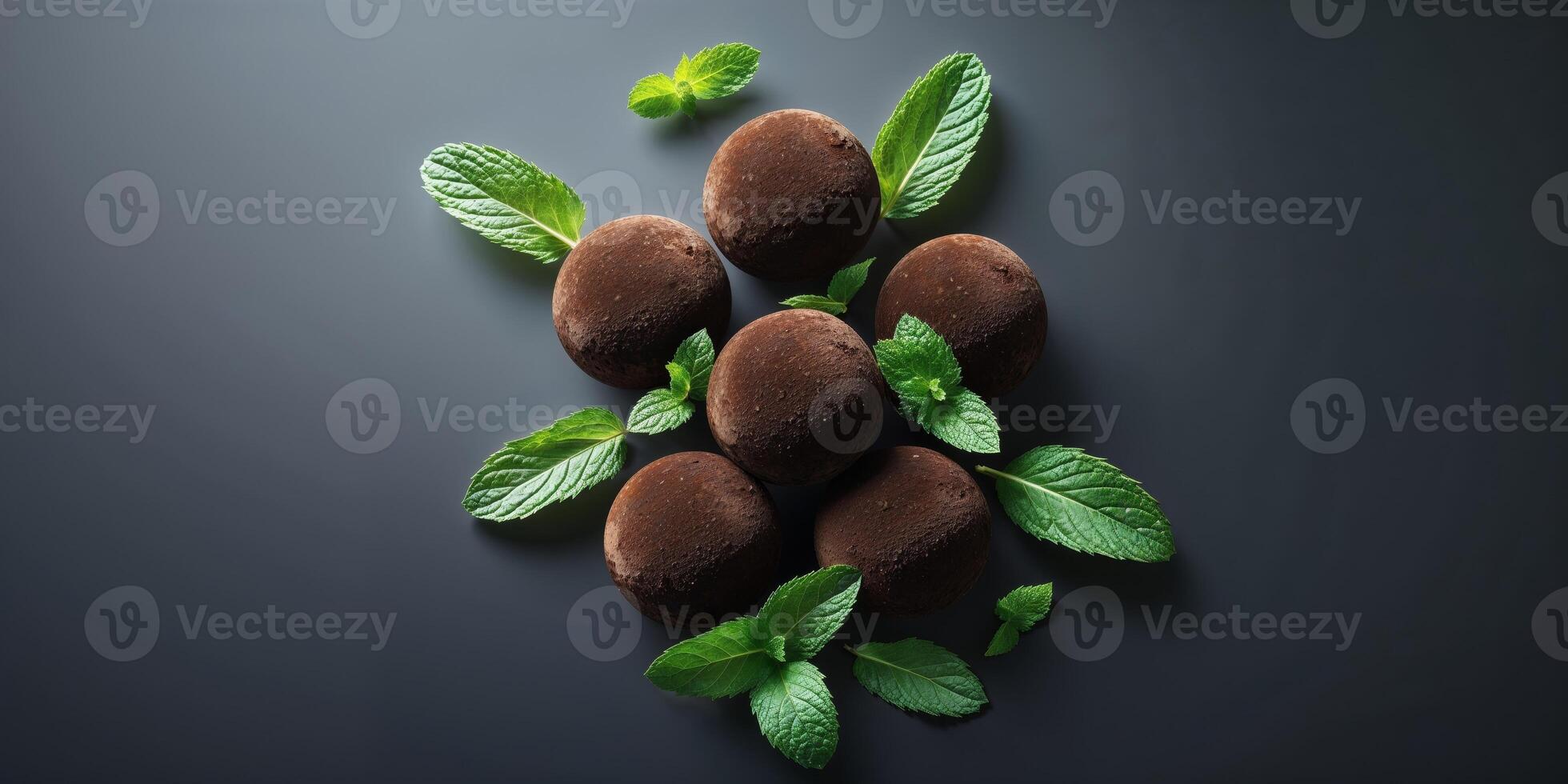 Cocoa truffles with mint leaves on dark background showcasing delicious chocolate desserts photo
