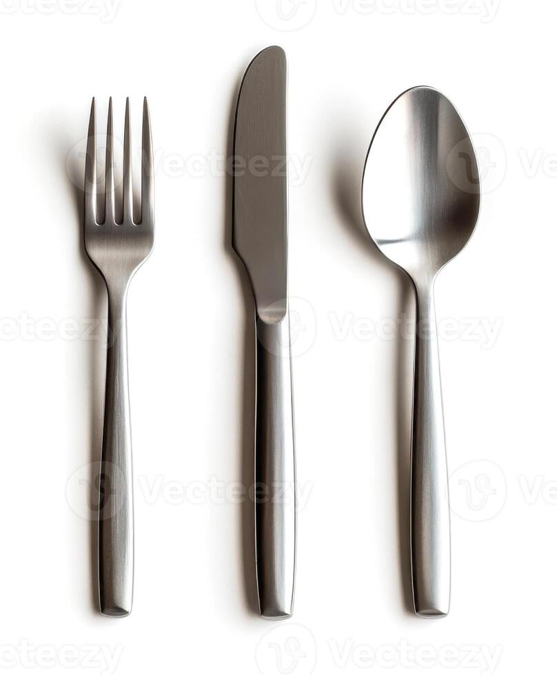 Cutlery set featuring fork, knife, and spoon with sleek stainless steel design on plain background photo