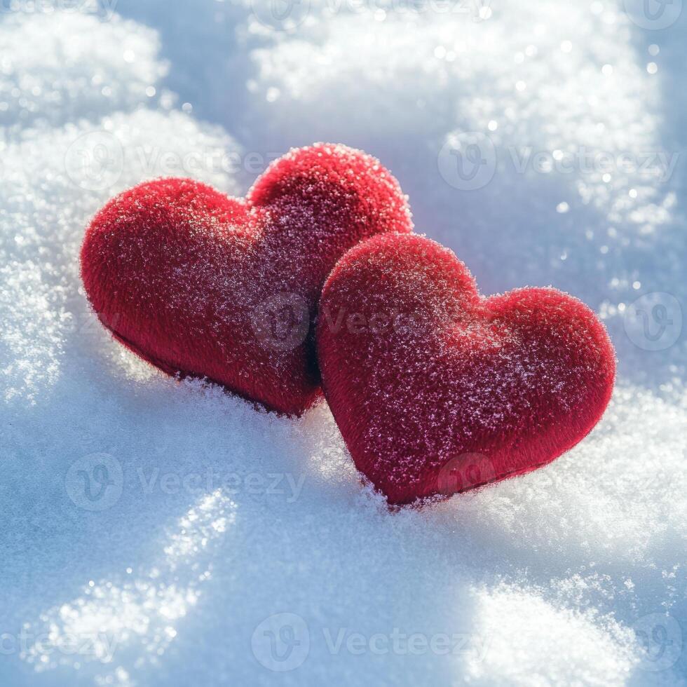 Red heart decorations resting on fresh snow during winter season creating a romantic atmosphere photo
