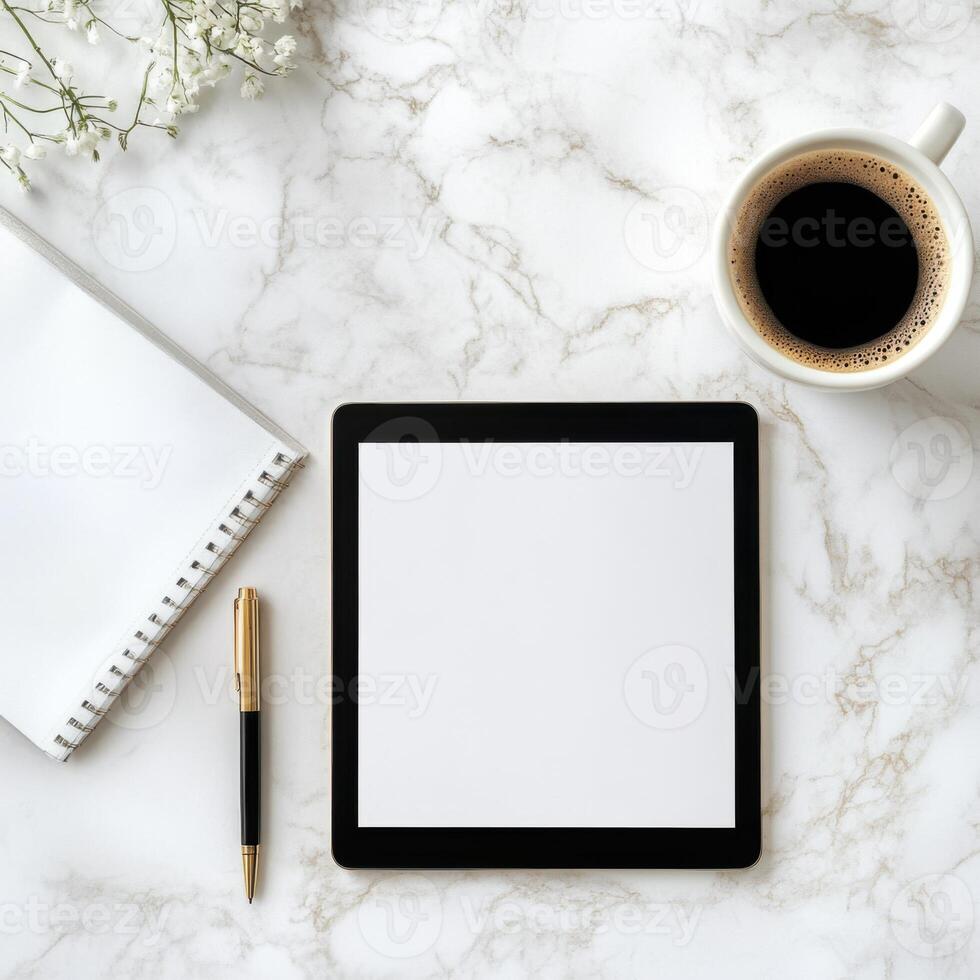 Workspace with tablet, notebook, pen, and coffee on marble surface creating a calm work environment for productivity photo
