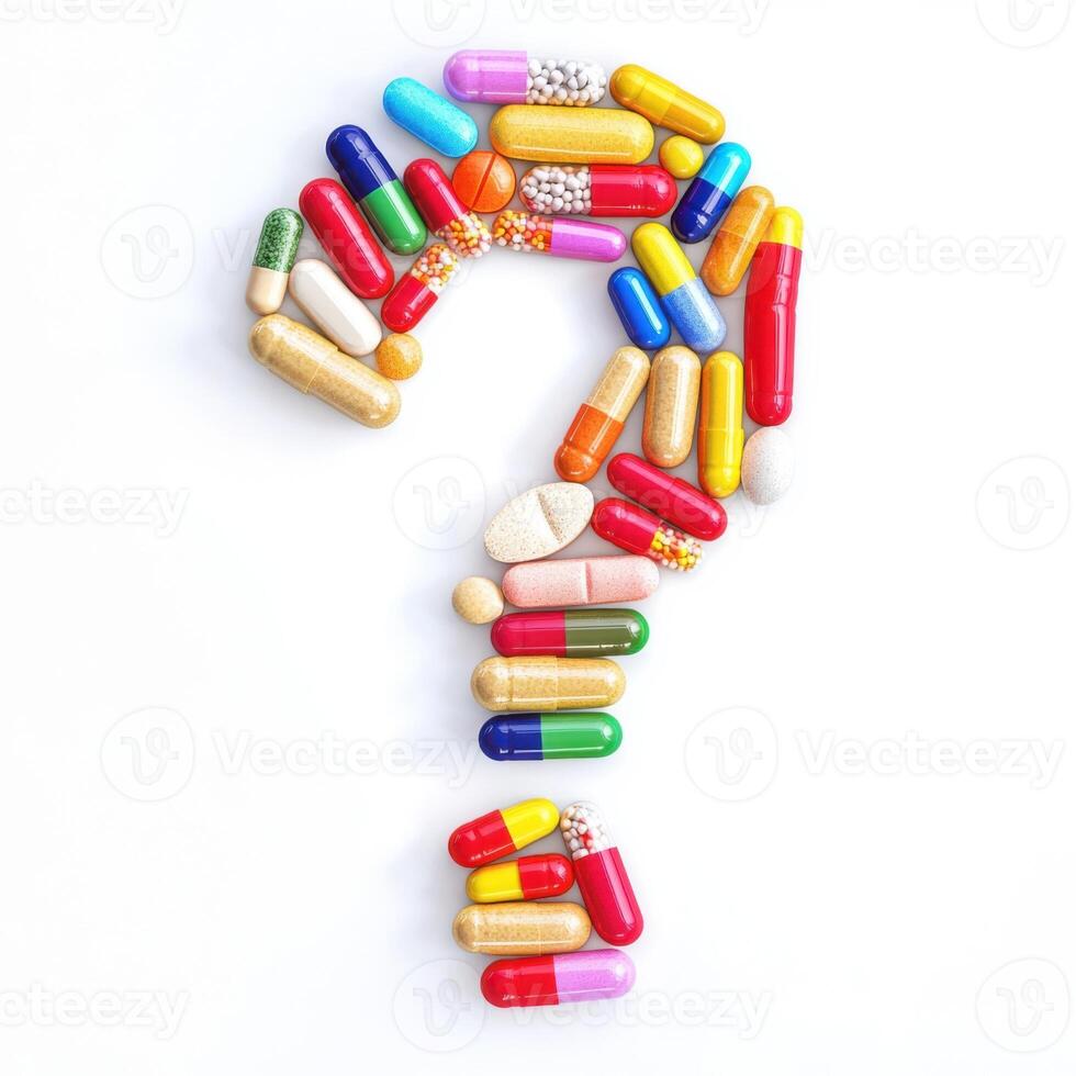 Colorful assortment of capsules arranged in the shape of a question mark on a white background photo