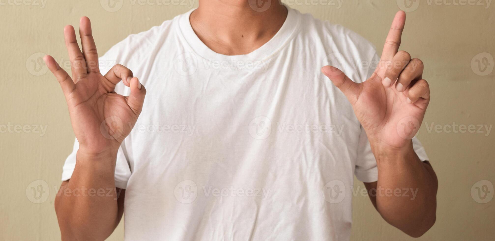 Young man view of pleased teacher showing alphabet letters on sign language photo