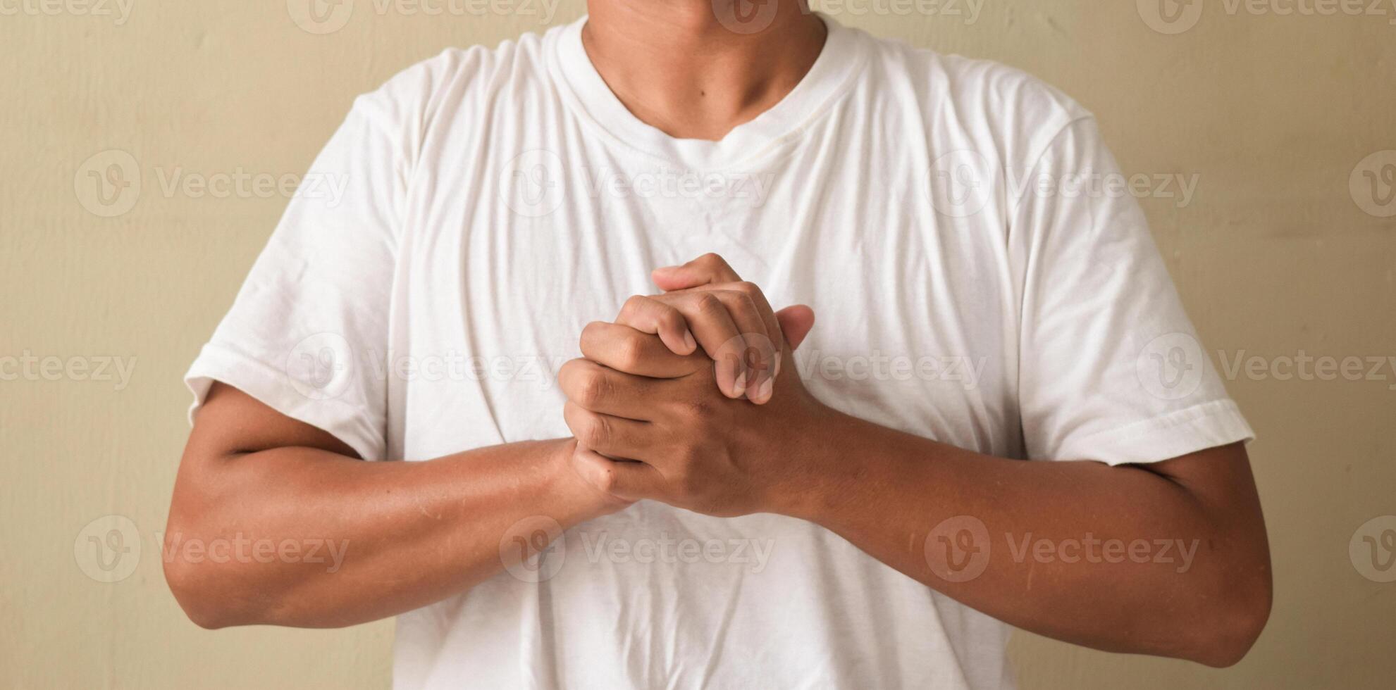 Young man showing symbol meaning friendship on sign language photo