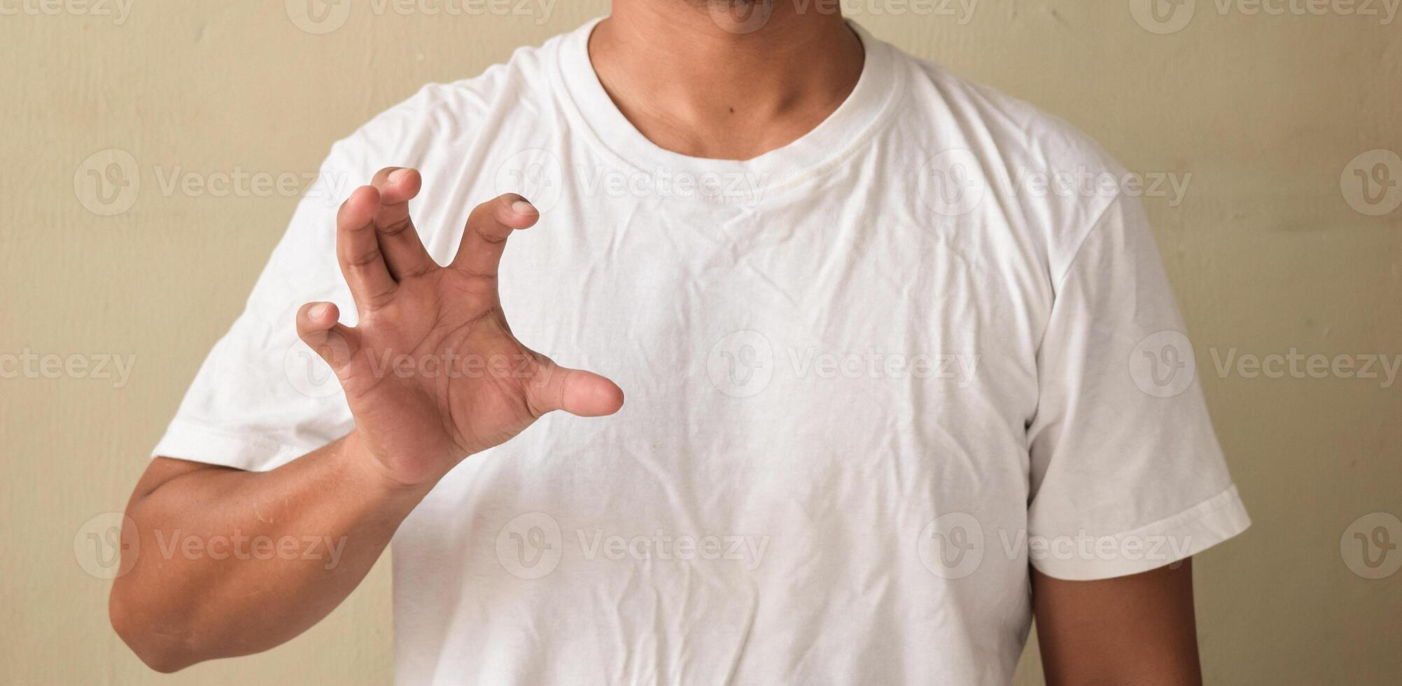Young man keeping his hand raised while using sign language photo