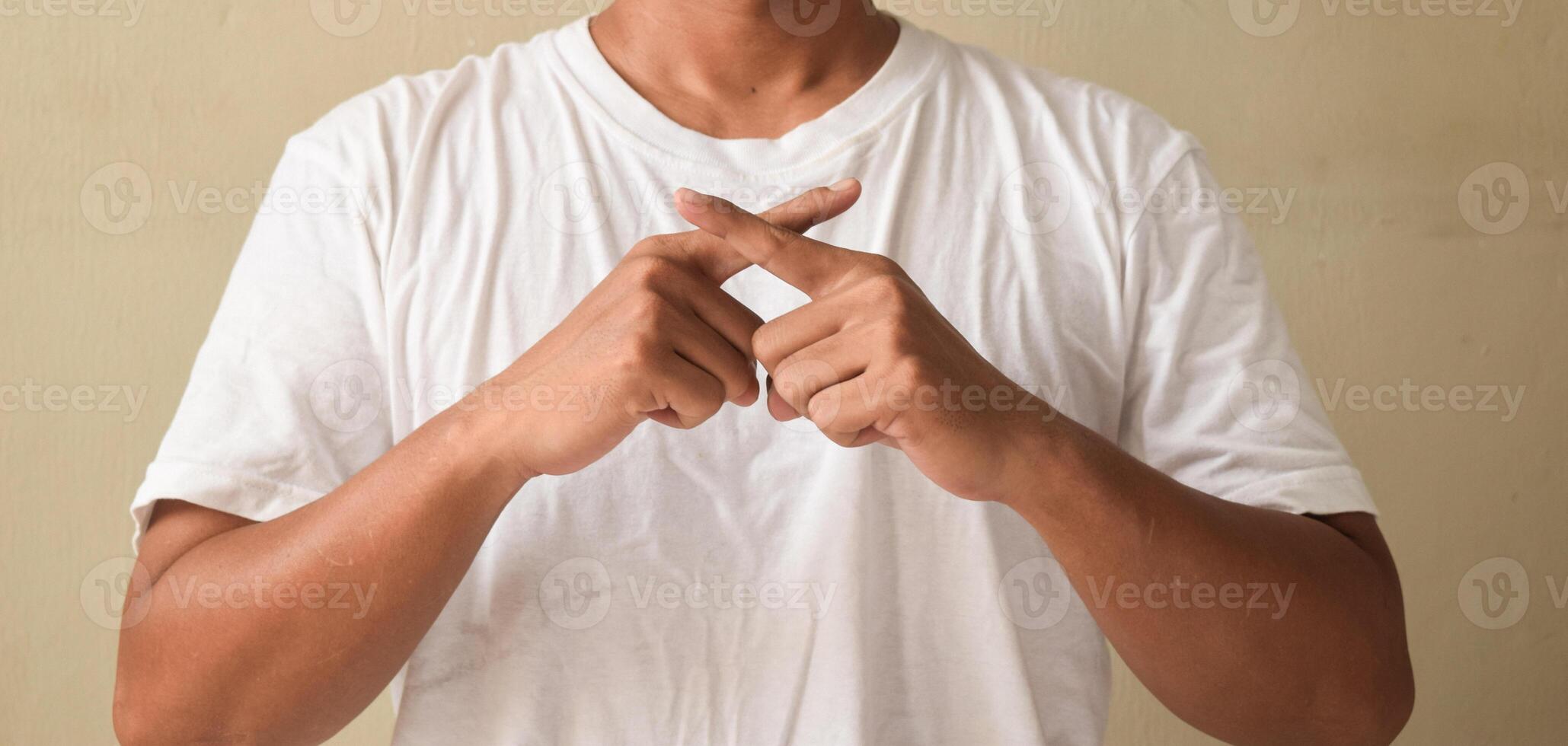 Young man raised hands being raised while speaking sign language, crossing index fingers while showing word engineer photo
