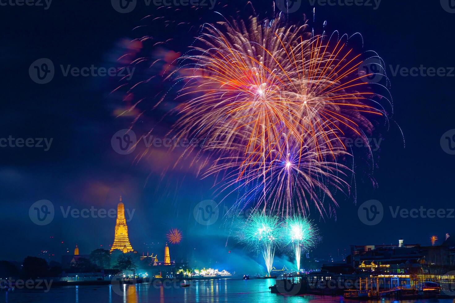 Beautiful lights fireworks of Chao praya river during New Year festival at night in Bangkok Thailand with Wat Arun Ratchawararam Ratchaworawihan Famous tourist attractions blur in background. photo