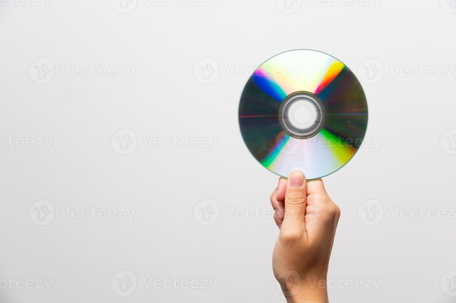 Hand holding CD or DVD disc against light on white background. Data erasure, old digital media, rarity photo