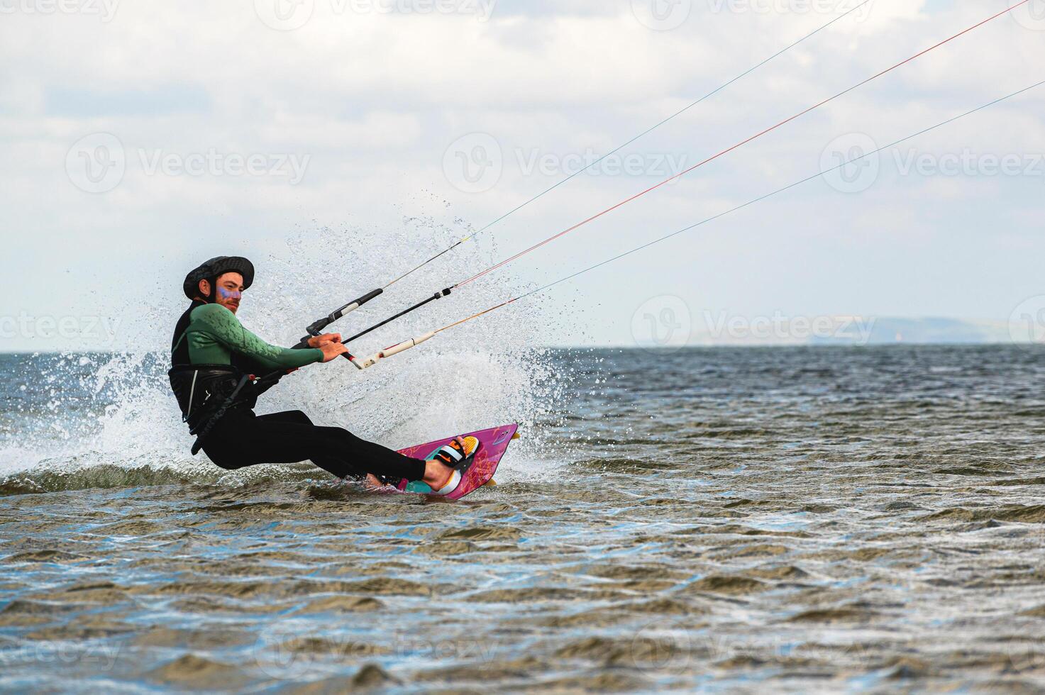 Professional kiter makes the difficult trick on a beautiful background. Kitesurfing Kiteboarding action photos man among waves quickly goes