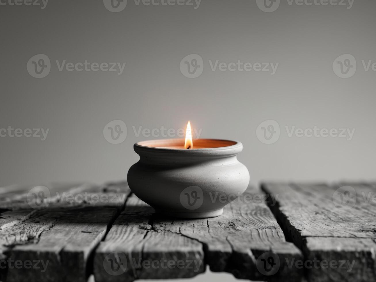 Elegant Clay Pot Candle with Flickering Flame on Rustic Wooden Table Surface photo
