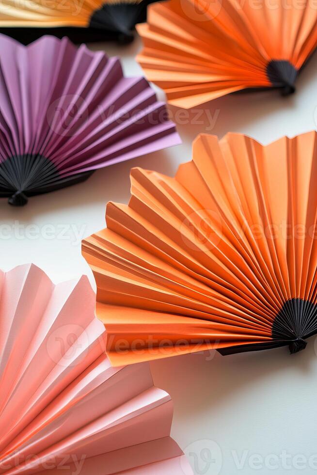 A collection of colorful paper fans are arranged in a row photo