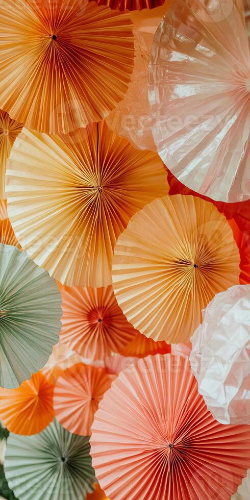 A bunch of paper fans are hanging from the ceiling, with some orange photo