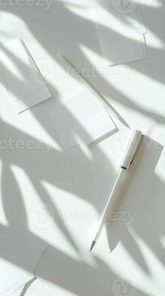 A pen is sitting on a white surface with a shadow of the pen on the surface photo