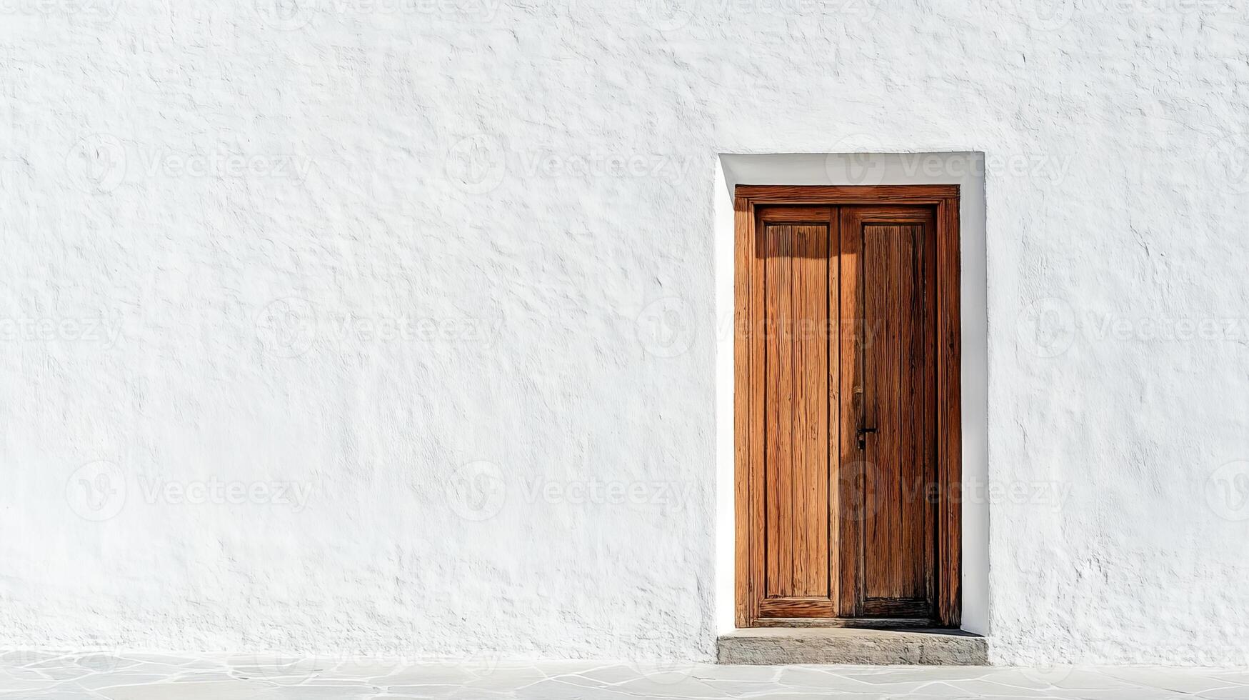 A wooden door with a white frame sits in front of a white wall photo