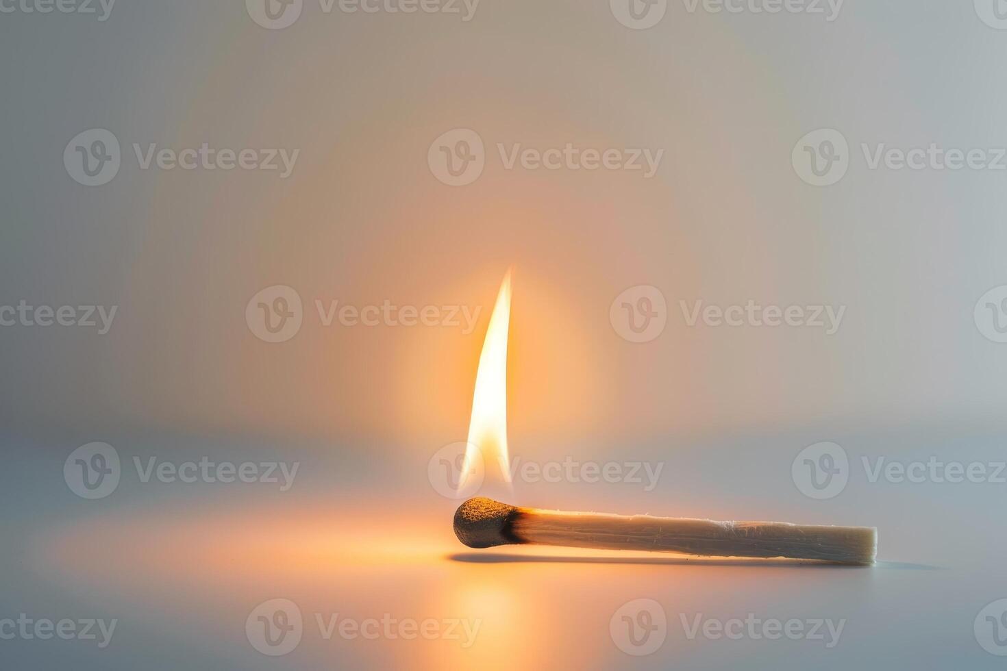 A match is lit and the flame is on the side of the match photo