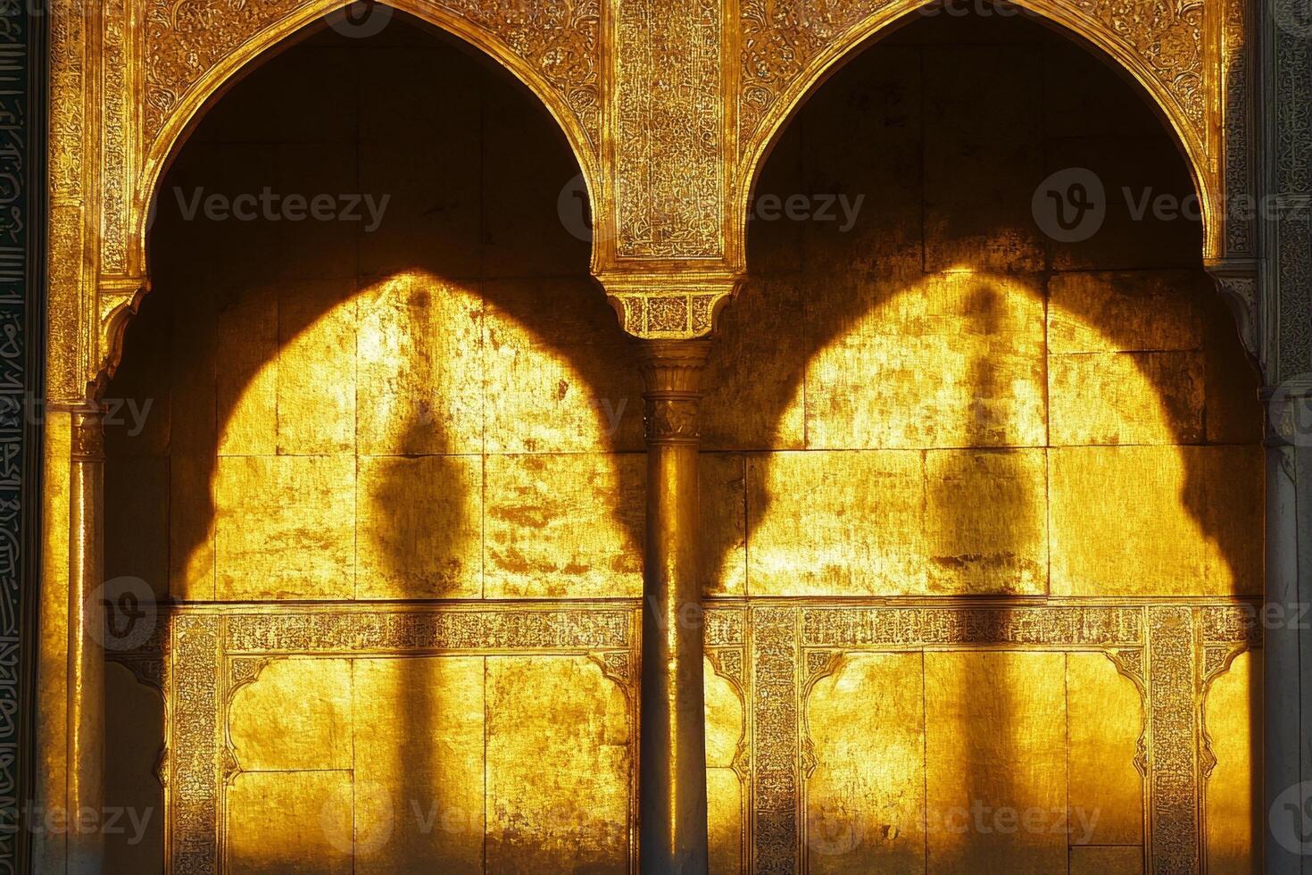 The archway is gold and has a shadow on it photo