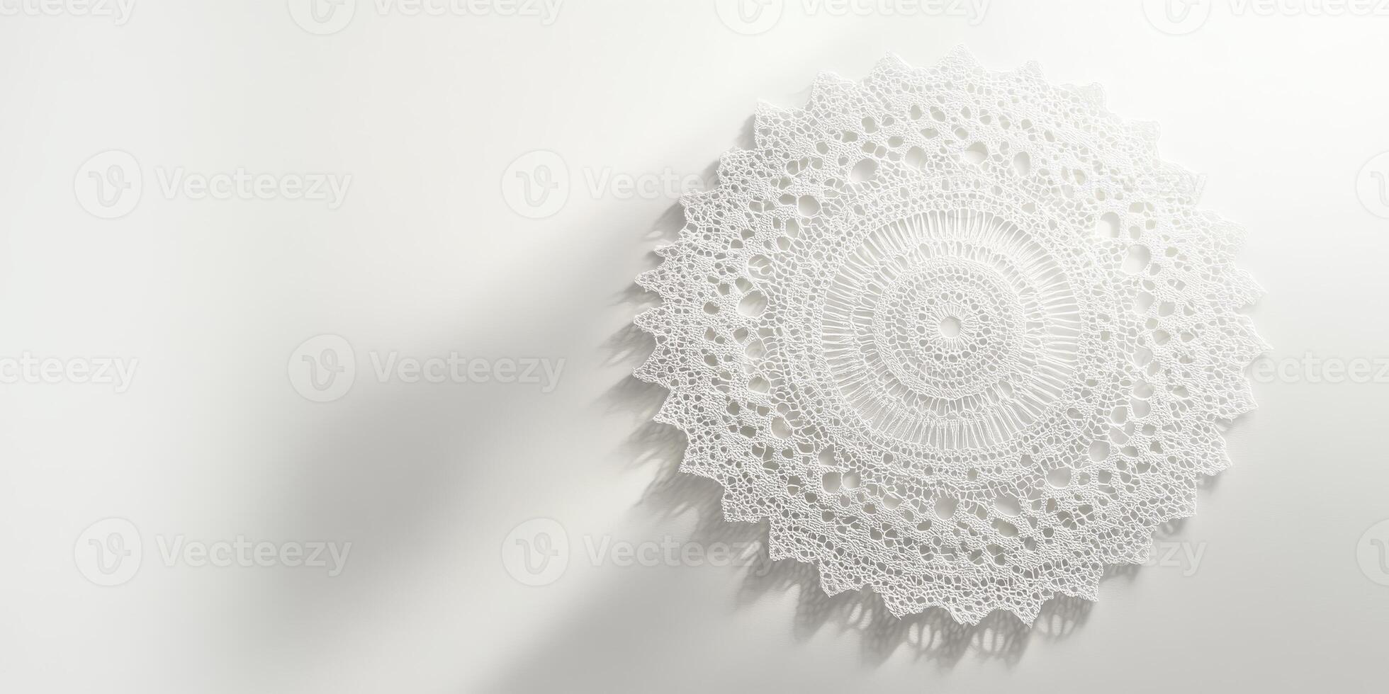 Detailed white crochet doily displayed on a plain white surface, showcasing intricate lace patterns and soft shadows. photo