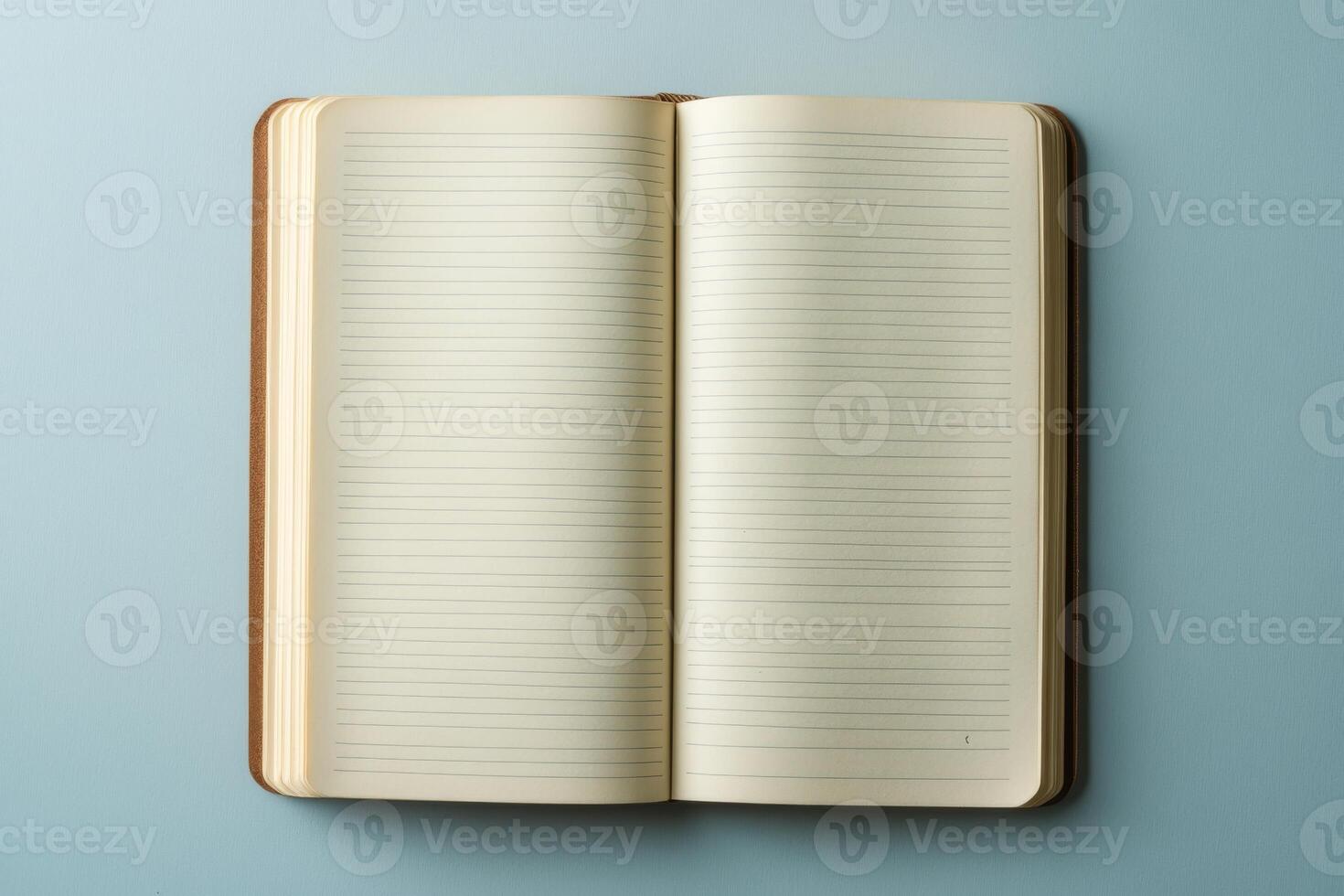A book is open to a blank page. The book is on a blue surface photo