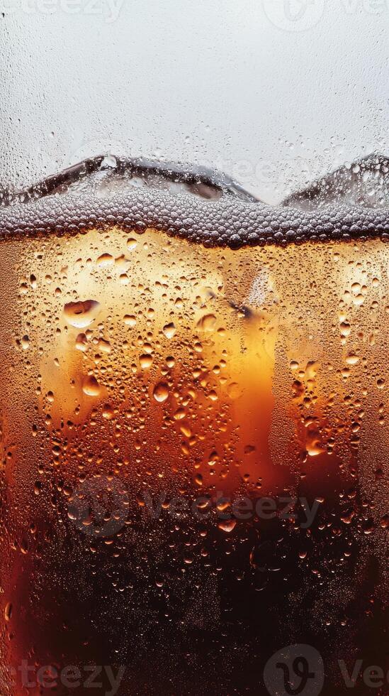 A glass of soda with ice cubes in it. The soda is fizzy and has a lot of bubbles photo
