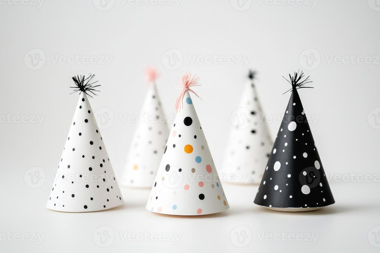 A row of party hats with polka dots and stars. The hats are in a row and are all different colors photo