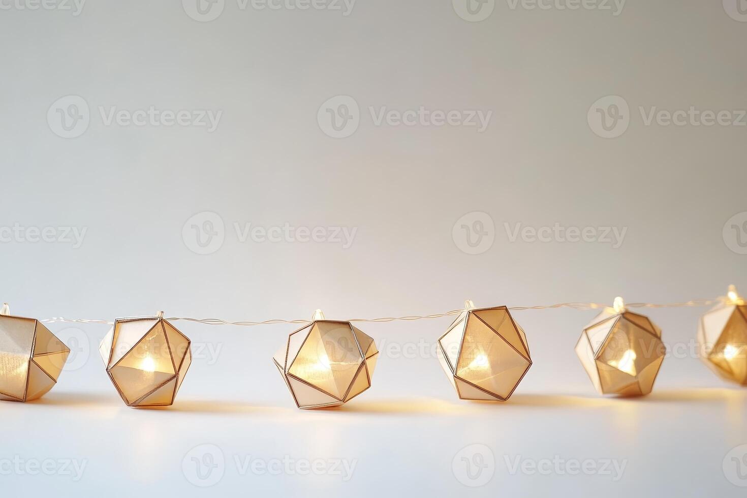A string of lights with a white background. The lights are shaped like cubes. There are nine lights in total photo