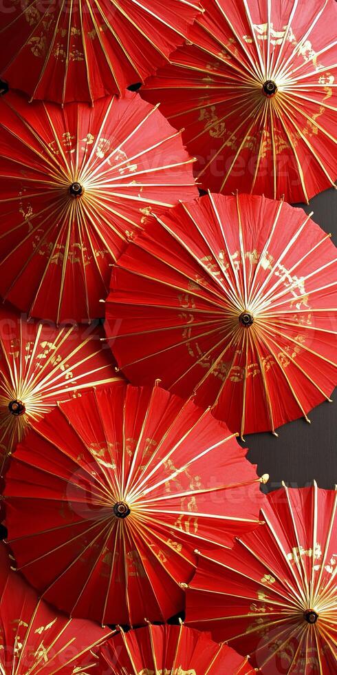 Close up of traditional red Japanese paper umbrellas with intricate gold designs, showcasing cultural artistry and vibrant colors. photo