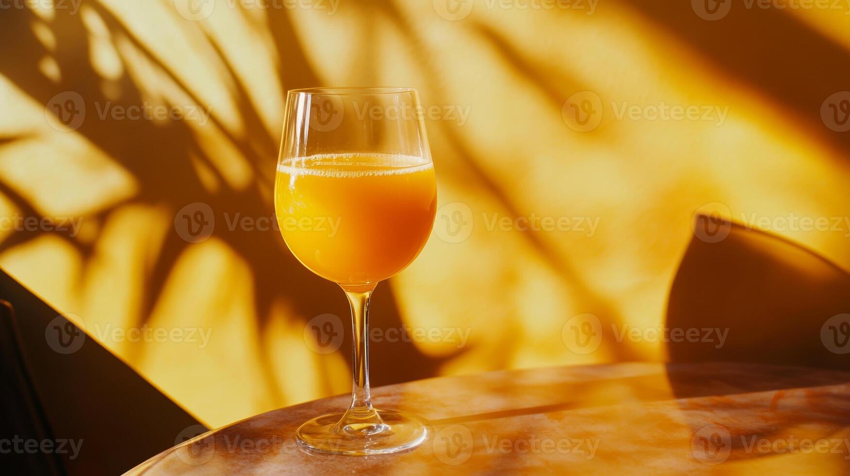 Bright Citrus Beverage in Glass with Shadow Patterns on Wall photo