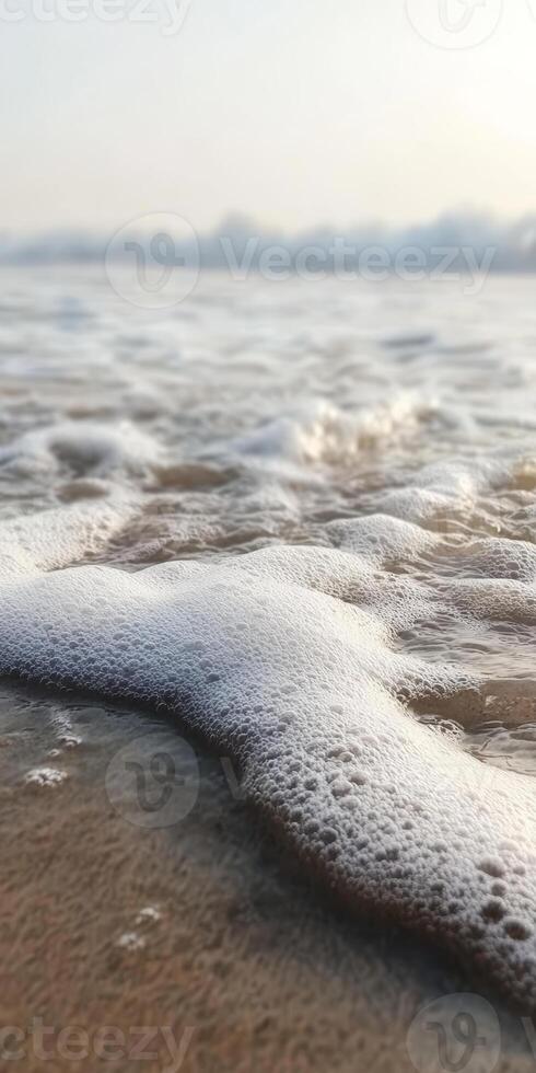 Serene Ocean Waves Gently Lapping on Sandy Beach at Sunrise with Soft Foam photo