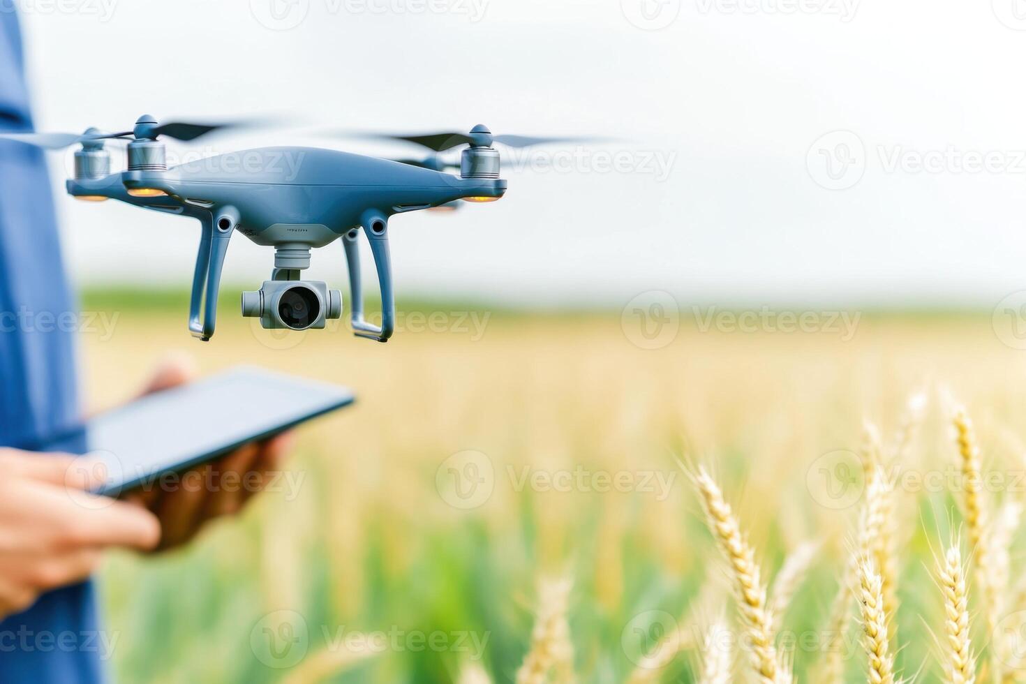 Farmer in wheat field using AI drone technology for crop monitoring and soil assessment with real-time data on a tablet photo
