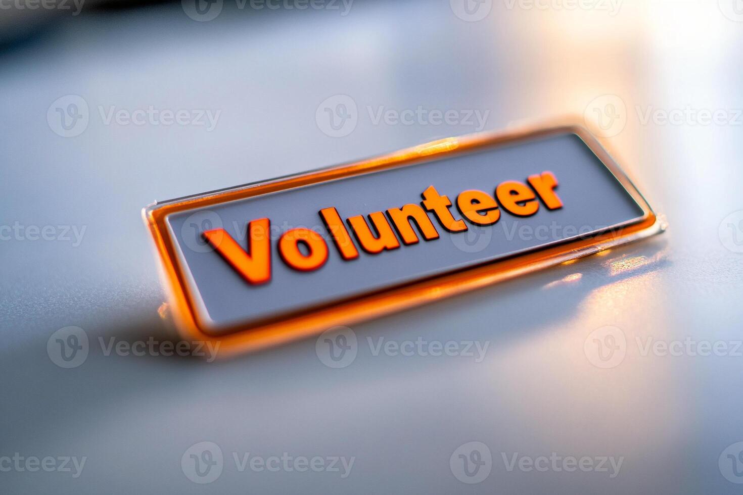 Close up of volunteer badge with bold red text reflecting in sunlight photo