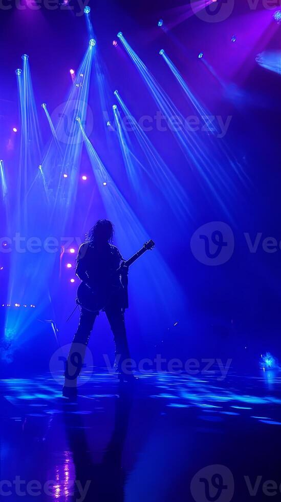 A person playing guitar in front of bright lights photo