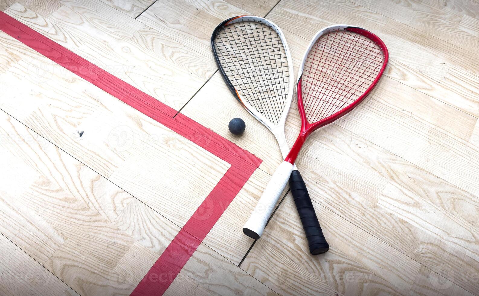 Squash rackets and ball on court floor, top view photo