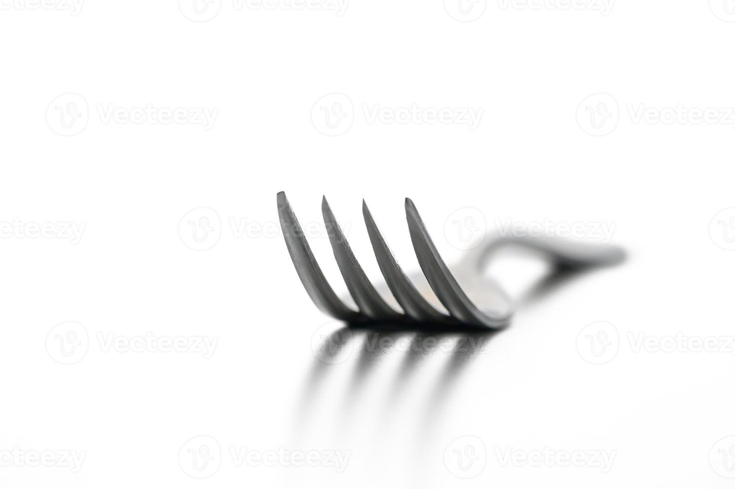 Sleek metallic fork resting on a reflective surface, capturing minimalist elegance in design photo