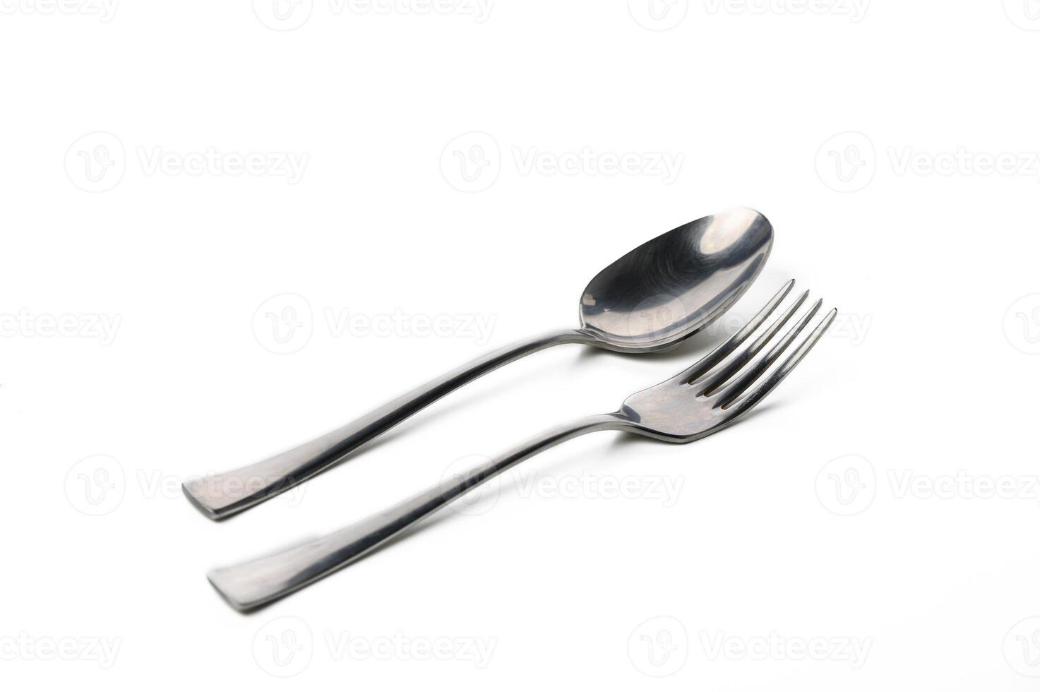 Elegant silver utensils quietly resting on a white surface in soft natural light photo