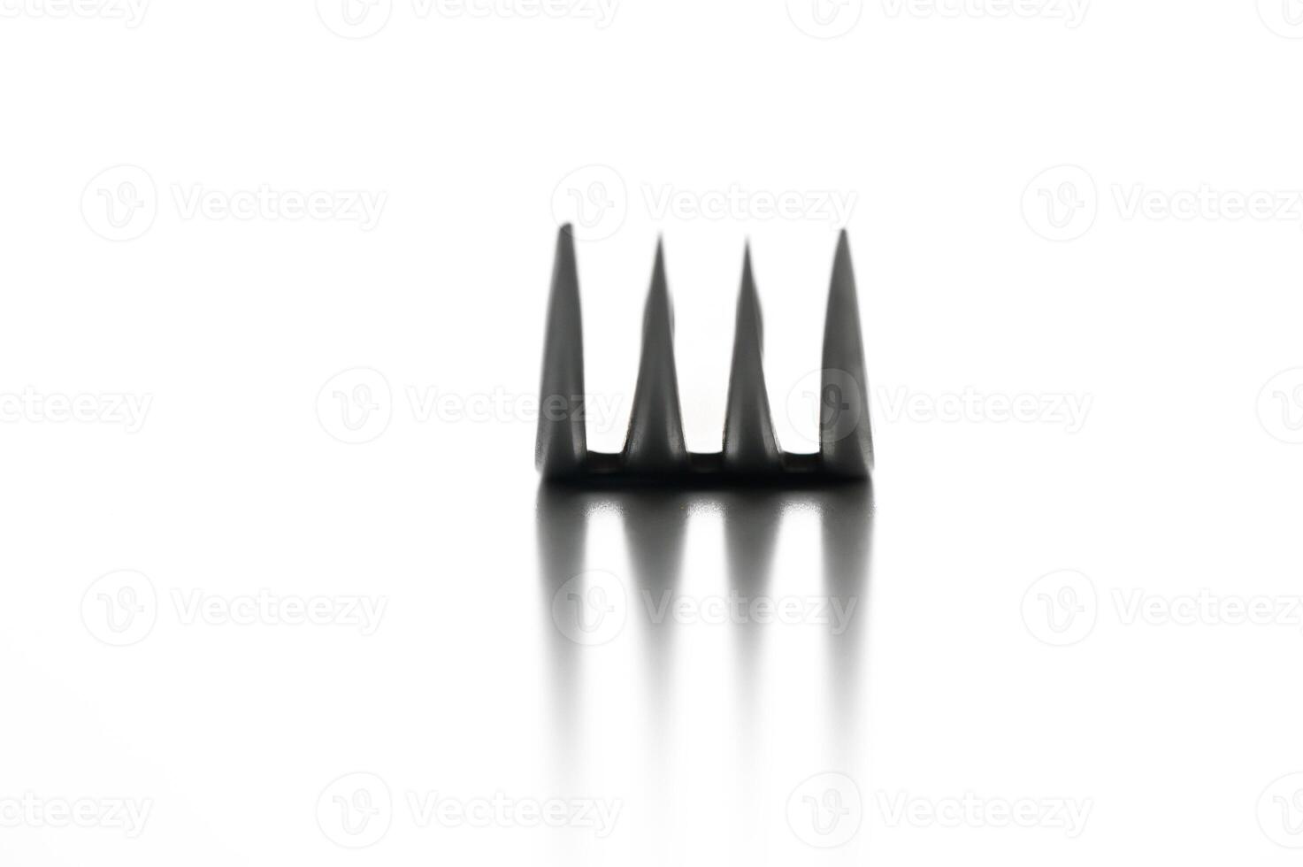 Unique black comb casting intriguing shadows on a reflective surface in minimalistic white background photo