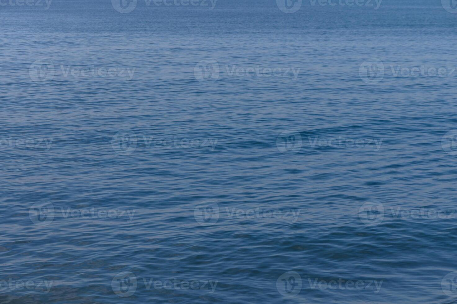 Calm azure waters reflect the sky in a serene seaside escape during midday photo