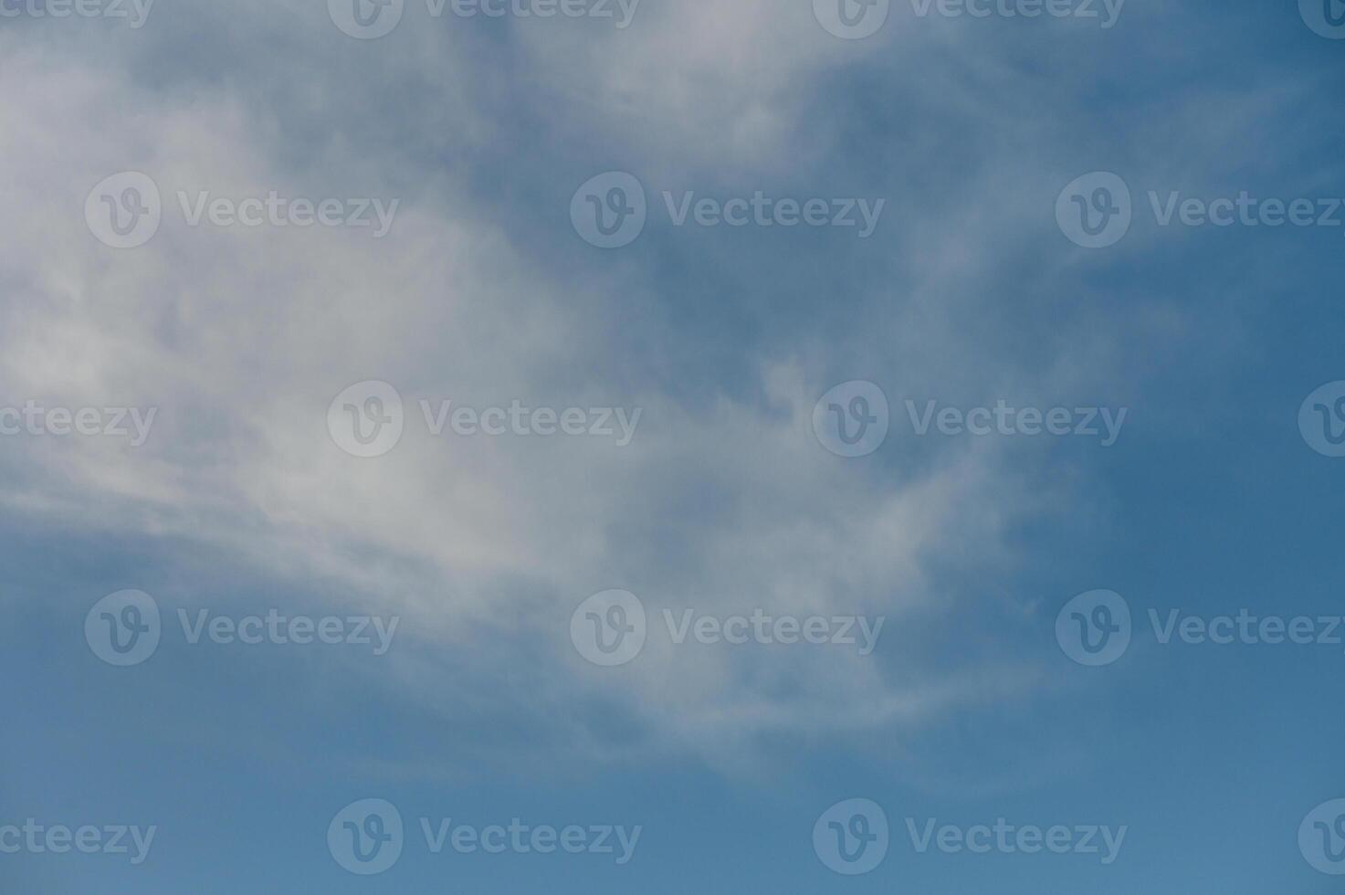 Endless azure sky with wispy clouds drifting lazily on a warm summer day photo
