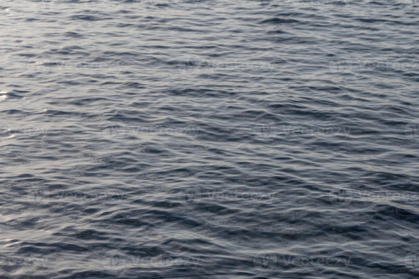 Calm waves reflecting soft light during a serene sunset over a tranquil ocean photo