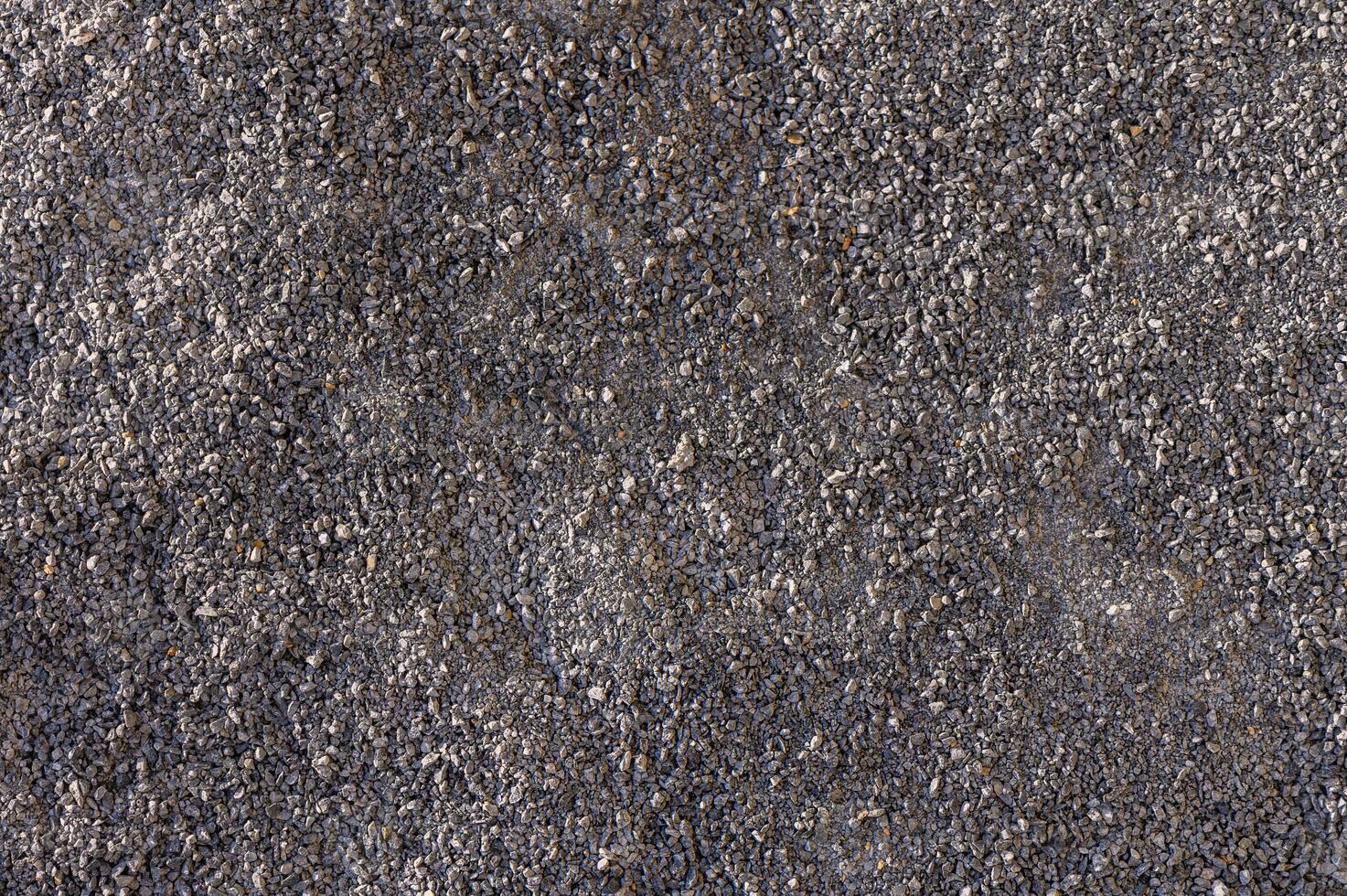 Textured surface of gravel creating a rough backdrop for artistic exploration in natural light photo