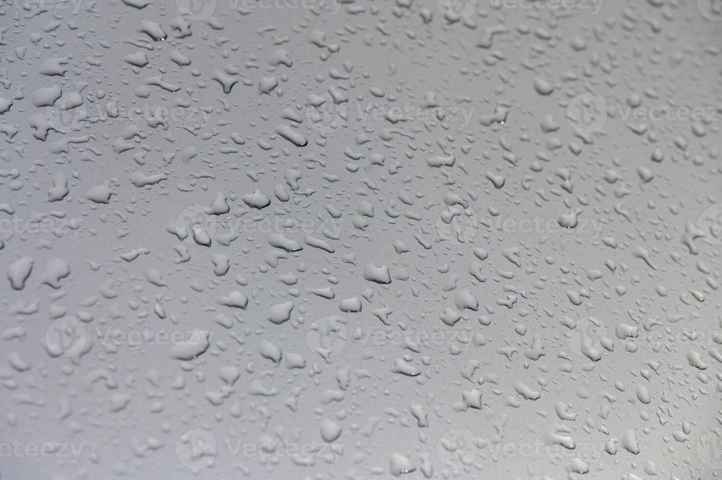 Raindrops shimmering on a windowpane creating a serene aquatic canvas during a quiet afternoon photo
