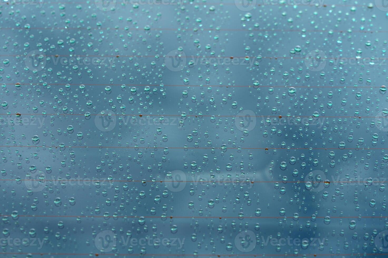 Reflections of a cloudy sky through rain-spattered glass on a tranquil afternoon photo