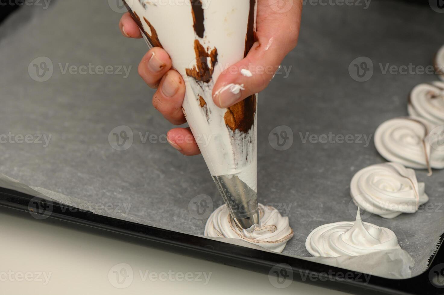 Mastering the art of meringue with swirls of chocolate on parchment photo