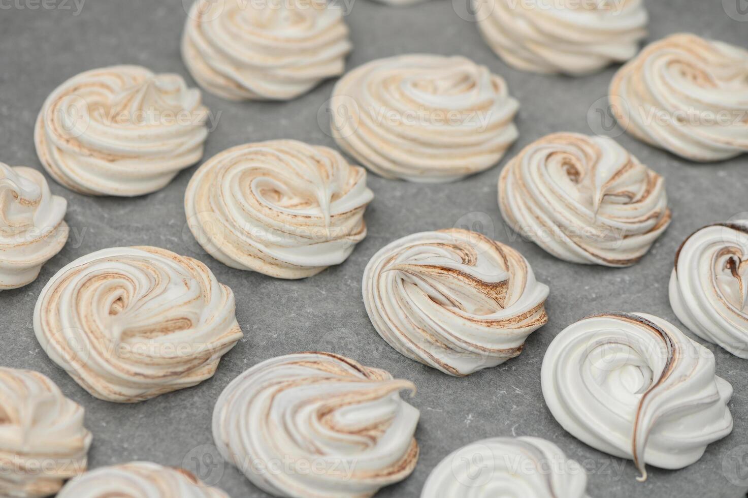 Delightful swirls of meringue cookies cooling on a countertop after being freshly baked in a cozy kitchen photo