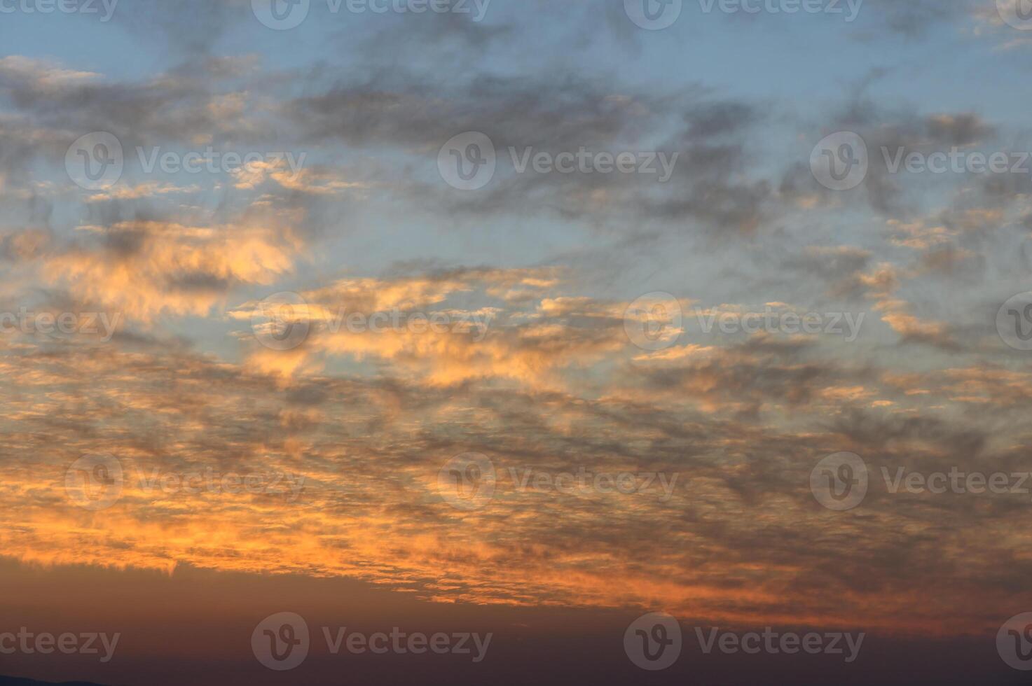 Majestic twilight sky painted with soft clouds and warm hues at dusk over the horizon photo