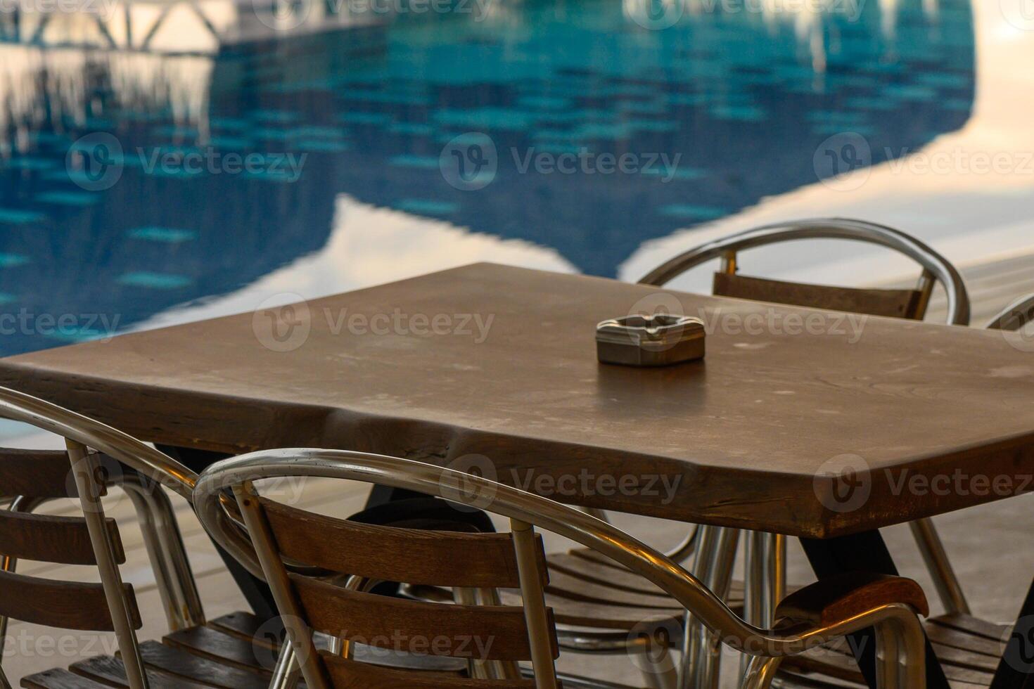 Relaxing moments by the poolside table as the sun sets, creating a tranquil vibe in a serene environment photo